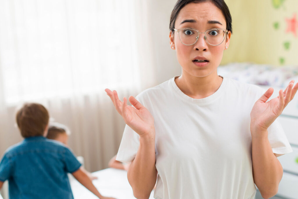 A woman in glasses is standing in front of a child's room during foster parents training.