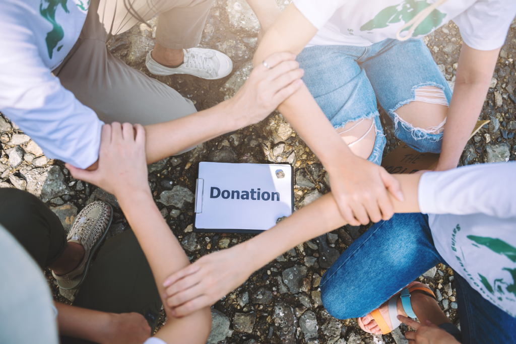 A group of foreign domestic workers holding hands around a donation box raise fund for free English lessons