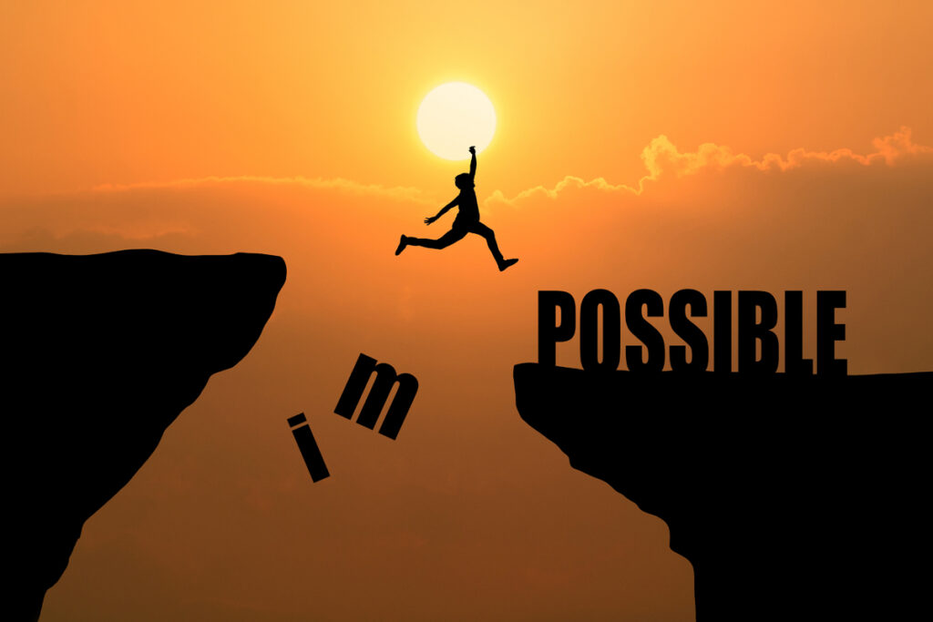 A man taking a leap of belief, jumping over a cliff with the word possible for ex prisoner to be gainfully employed
