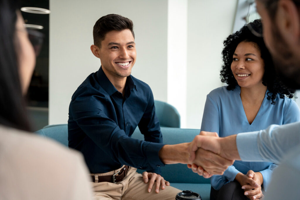 A ex-con shaking hand with employer during job interview, helping ex-offenders find jobs