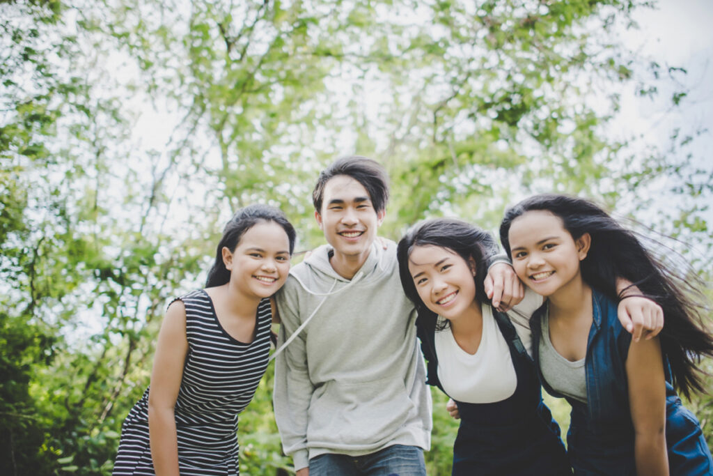A group of young Asian volunteers helping ex-offenders find jobs while posing for a picture.